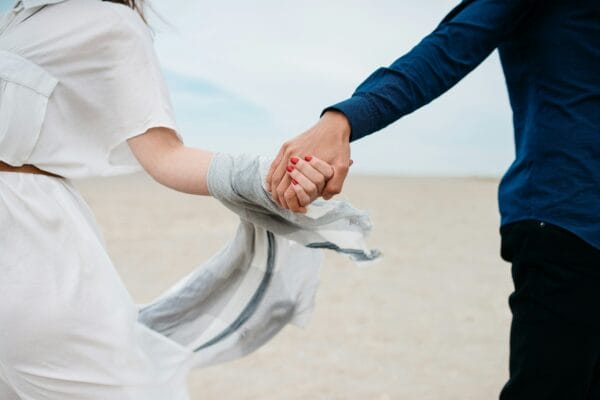 Happy couple holding hands at the beach